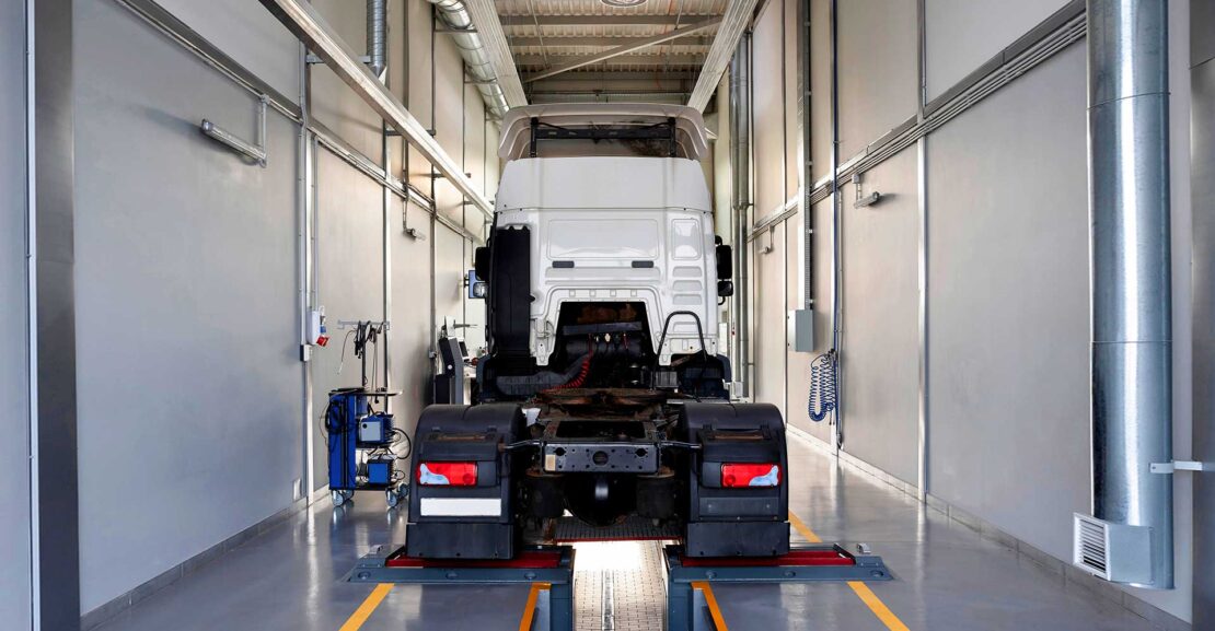 Truck cab in a large service bay for maintenance.