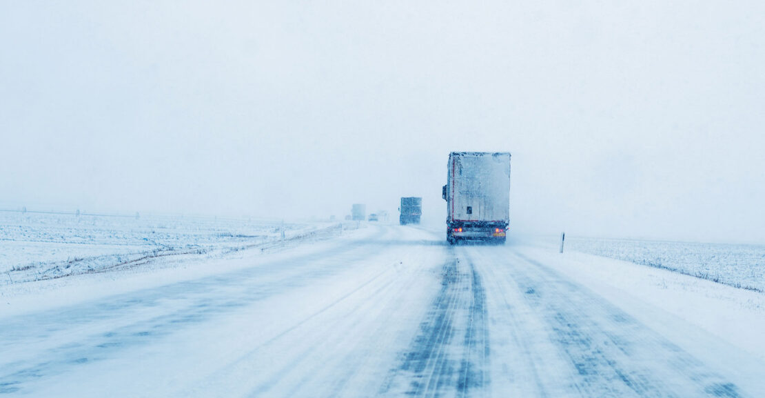 Freight transportation truck on the road in snow storm blizzard