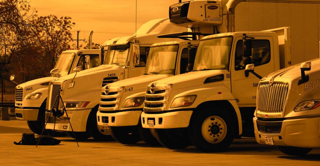 Row of various commercial trucks with an amber overall stylized coloring.