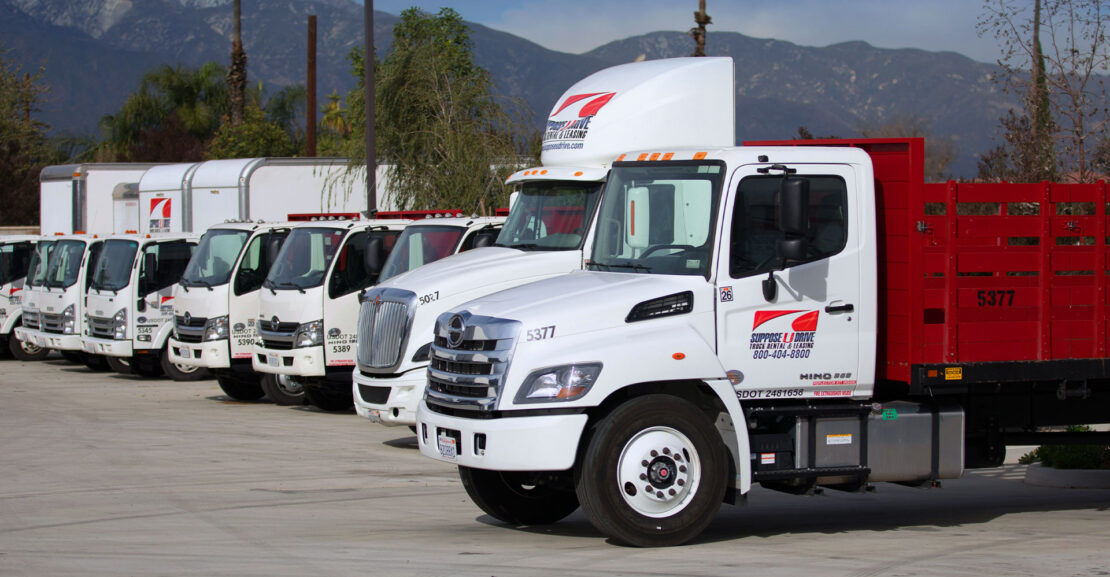 Row of various commercial trucks with the San Gabriel Mountains in the background