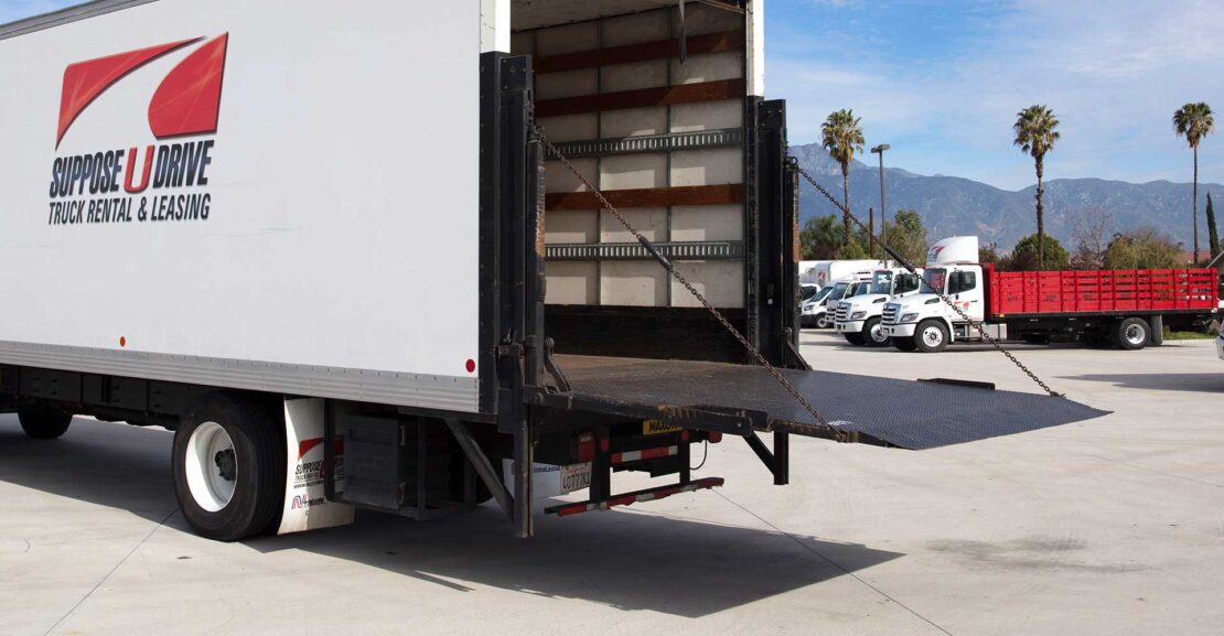 Rear of box truck with a cantilever liftgate extended.