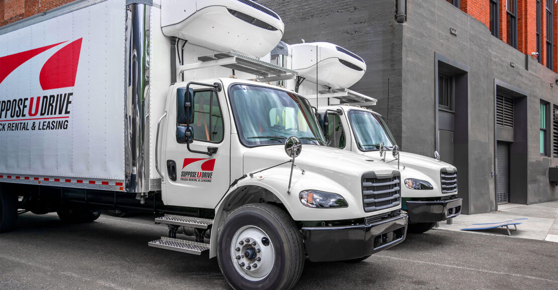 Two white reefers sitting at loading dock