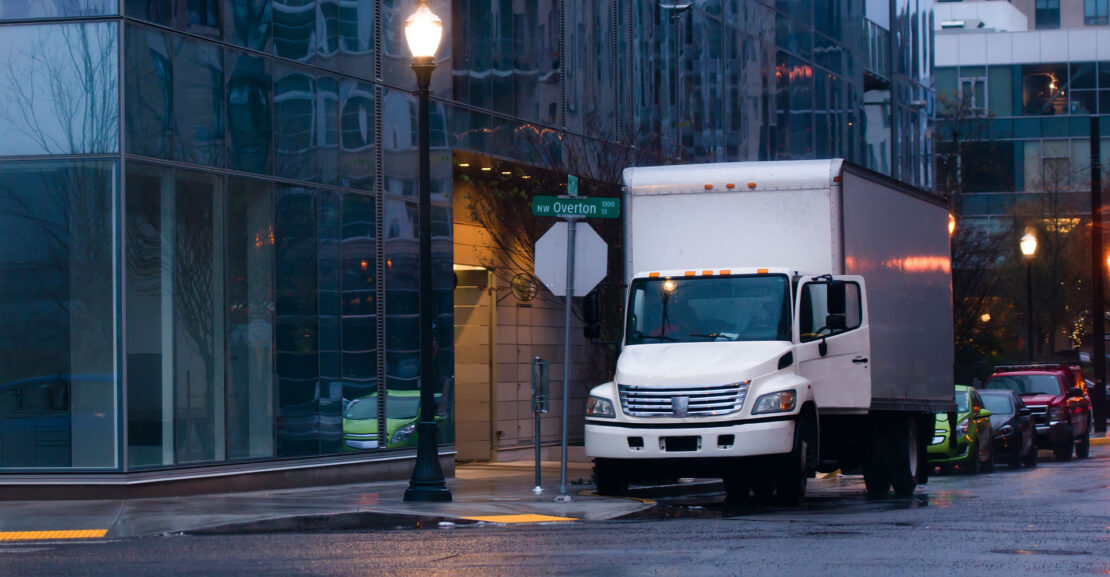 Semi truck with box trailer in night rainy city street