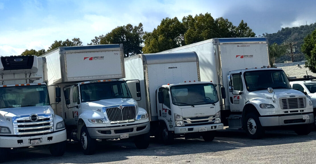 Row of a variety of types of commercial trucks for rent.