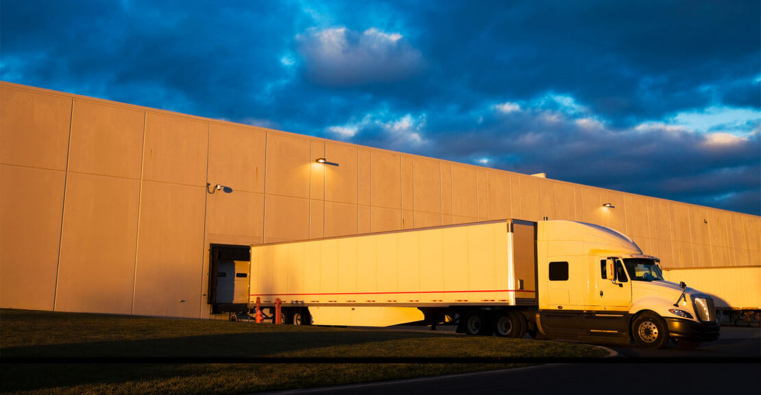 Semi tractor trailer sitting at loading dock.